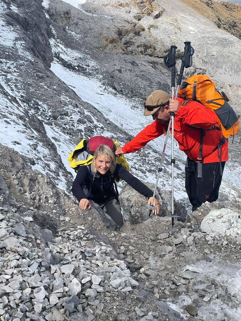 David, guía de Muntania Outdoors, ayudando a una cliente en un viaje de montaña