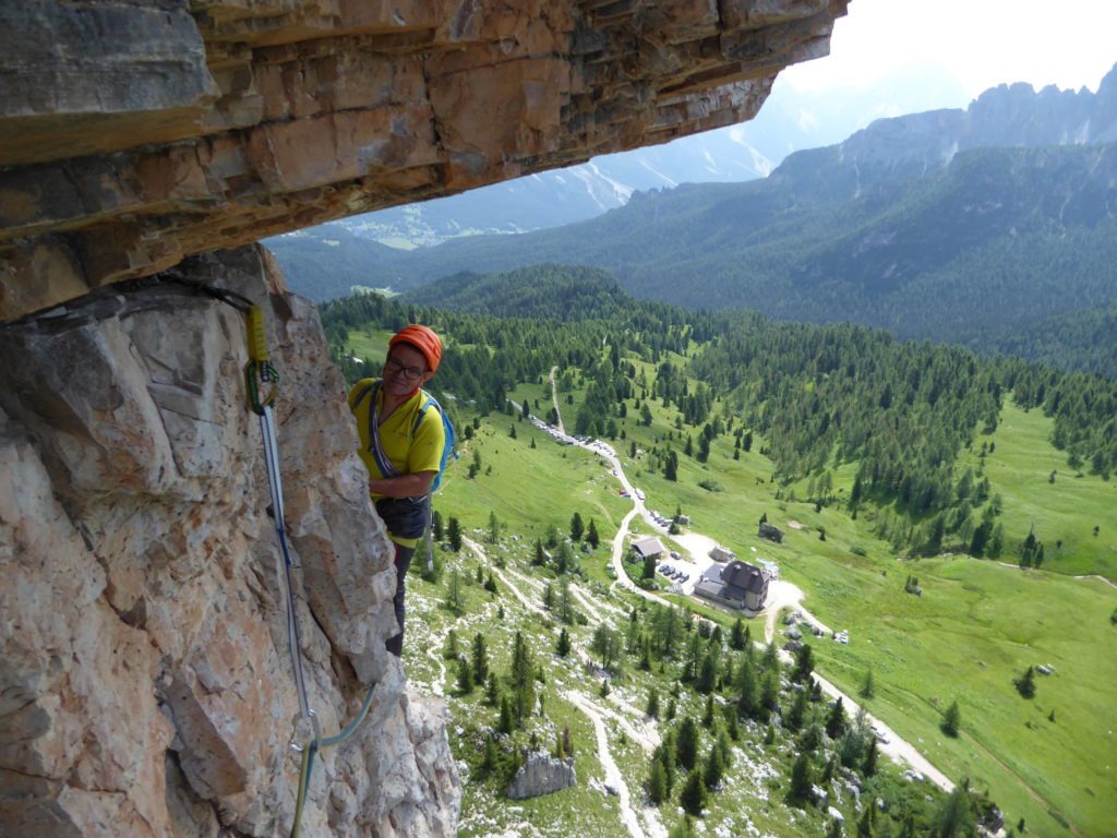 Un escalador descansa en una reunión en una pared de los Alpes