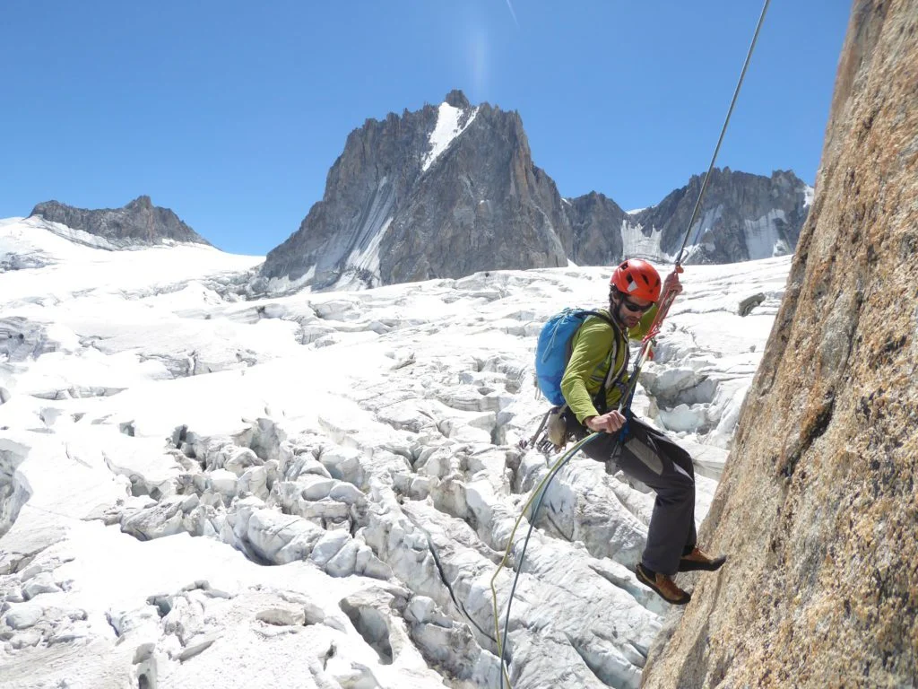 Un escalador rapela en una pared sobre un glaciar de los Alpes