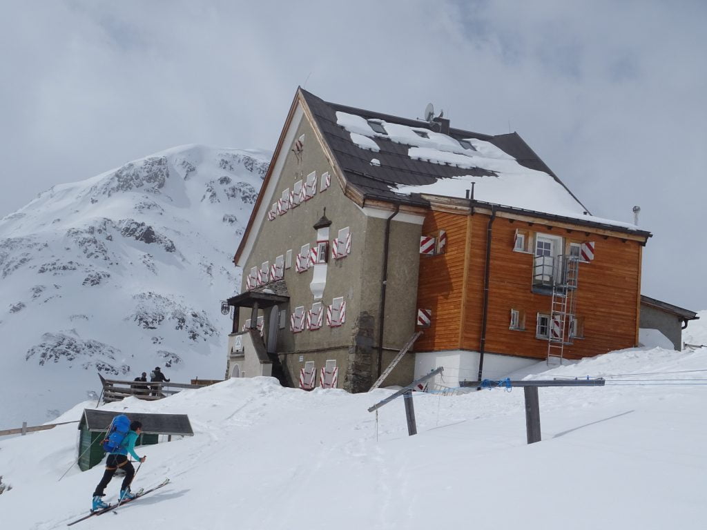 Esquiador de montaña llegando a un refugio en los Alpes